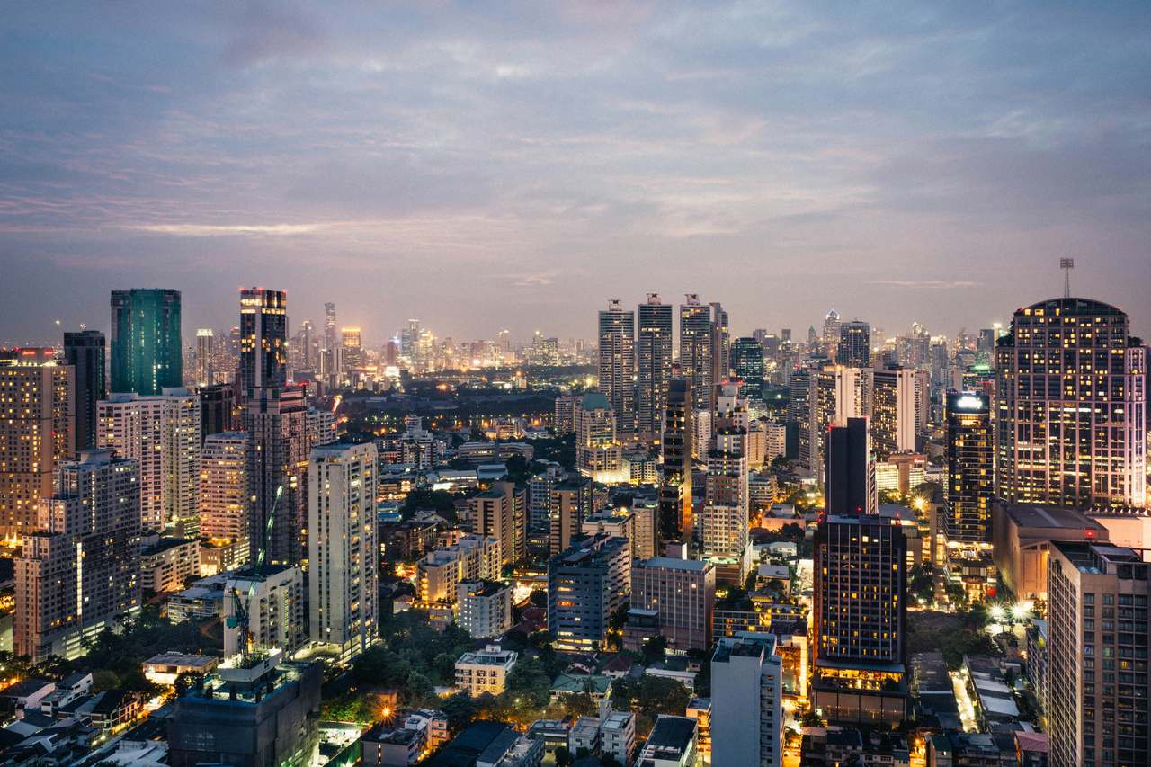 Bangkok skyline at dusk, with city lights coming on across the business district